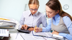 Concentrated business women reviewing accounting report
