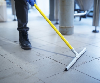 Close up of mop cleaning industrial plant floor.