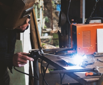 Man welding old shovel, close up